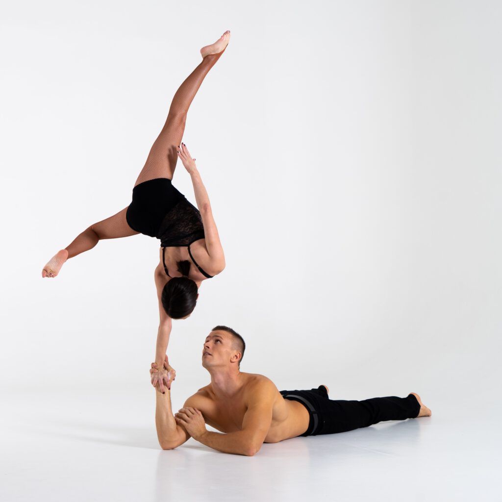 Akrobatik: Einarmiger Handstand auf dem Unterarm des liegenden Partners